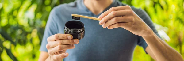 Anak muda sikat gigi menggunakan bubuk arang aktif untuk menyikat dan memutihkan gigi. Bamboo eco brush BANNER, LONG FORMAT — Stok Foto