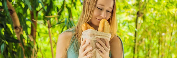 Genç bir kadının ellerinde ekmek olan yeniden kullanılabilir alışveriş torbaları. Sıfır atık. Sıfır atık konsepti Banner, Uzun Biçim — Stok fotoğraf