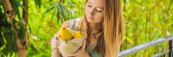 Mango tekrar kullanılabilir bir çantada, kadınların elinde. Sıfır atık kavramı, plastiksiz kavram. Sağlıklı beslenme ve detoks. Yaz Meyveleri Bayrağı, Uzun Format — Stok fotoğraf