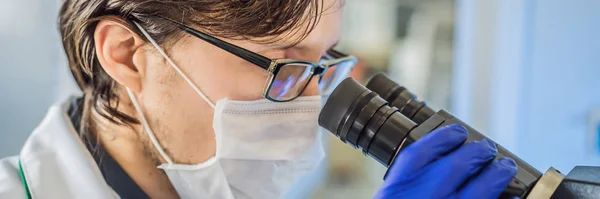 Retrato de homem branco químico pesquisador científico usando microscópio no laboratório interior coronavírus BANNER, LONG FORMAT — Fotografia de Stock