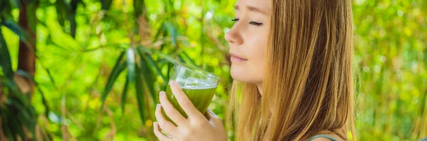 Junge Frau trinkt Selleriesaft, Gesundes Getränk, Selleriestrauß auf hölzernem Hintergrund — Stockfoto