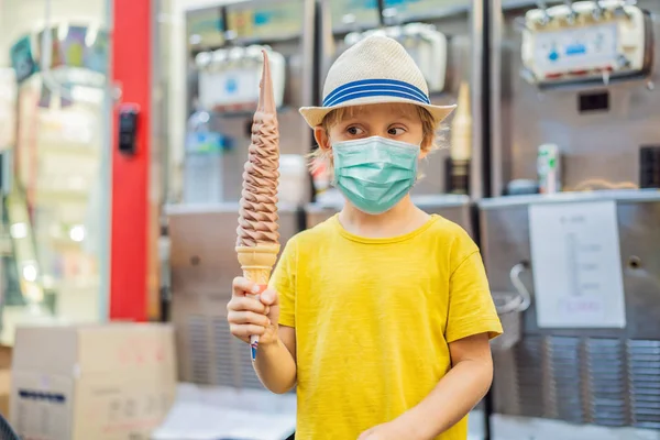 Little tourist boy in medical mask eating 32 cm ice cream. 1 foot long ice cream. Long ice cream is a popular tourist attraction in Korea. Travel to Korea concept. Traveling with children concept