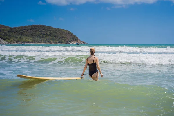 Belle jeune femme monter vague. Surfeuse sportive surfant sur fond de ciel bleu, de nuages et de vagues transparentes. Extérieur actif — Photo