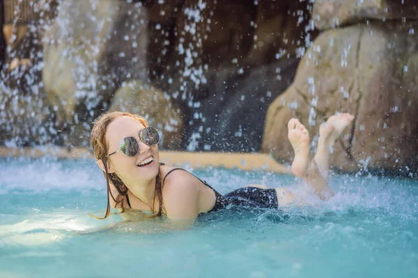 Young joyful woman under the water stream, pool, day spa, hot springs — Stock Photo, Image