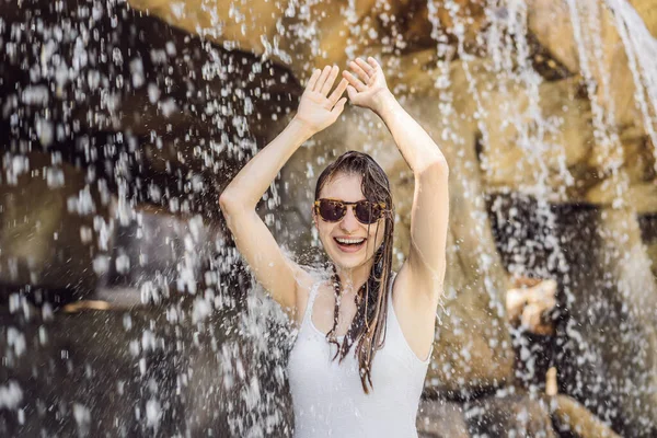 Jonge vrolijke vrouw onder de waterstroom, zwembad, spa, warmwaterbronnen — Stockfoto