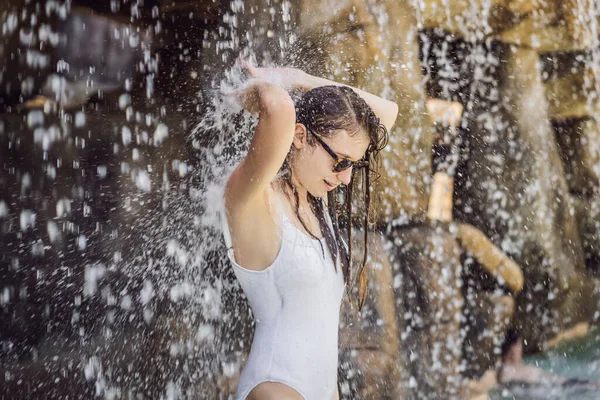 Junge fröhliche Frau unter dem Wasserstrom, Pool, Tagesbad, heiße Quellen — Stockfoto