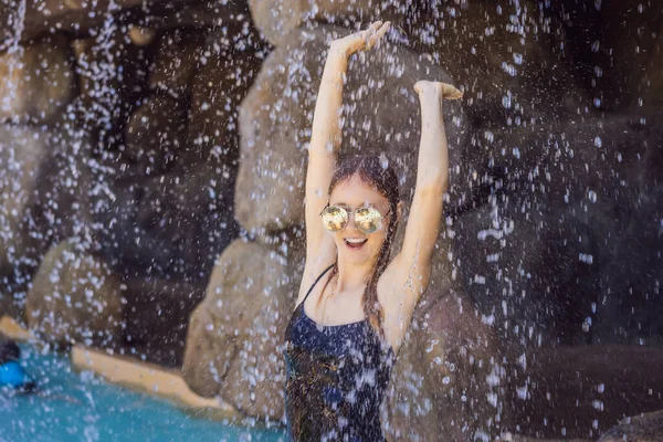 Junge fröhliche Frau unter dem Wasserstrom, Pool, Tagesbad, heiße Quellen — Stockfoto