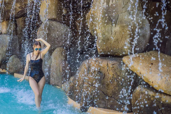 Young joyful woman under the water stream, pool, day spa, hot springs — Stock Photo, Image