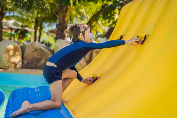 Garçon mignon court un parcours d'obstacles gonflable dans la piscine — Photo