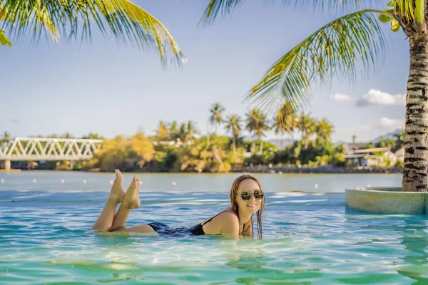 Luxus Resort Schwimmbad. Schöne Touristin erholt sich in Urlaub Rückzug auf Sommerreise Urlaub. Bikini-Mädchen im Sonnenbad Badeanzug genießen Ozean Hintergrund — Stockfoto