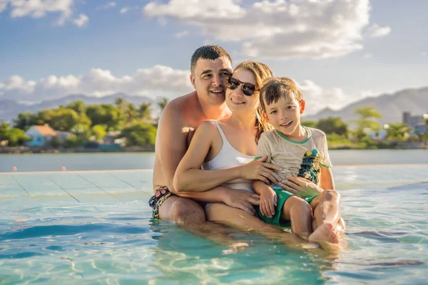 Piscina resort di lusso. Felice famiglia turisti rilassante in vacanza rifugio sulla vacanza estiva di viaggio godendo sfondo oceano — Foto Stock