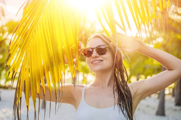 Jonge mooie vrouw in badpak op tropisch strand, zomervakantie, palmblad, gebruinde huid, zand, glimlachen, gelukkig. Gelukkige reiziger vrouw — Stockfoto