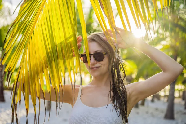 Joven hermosa mujer en traje de baño en la playa tropical, vacaciones de verano, hoja de palmera, piel bronceada, arena, sonriente, feliz. Mujer viajera feliz — Foto de Stock