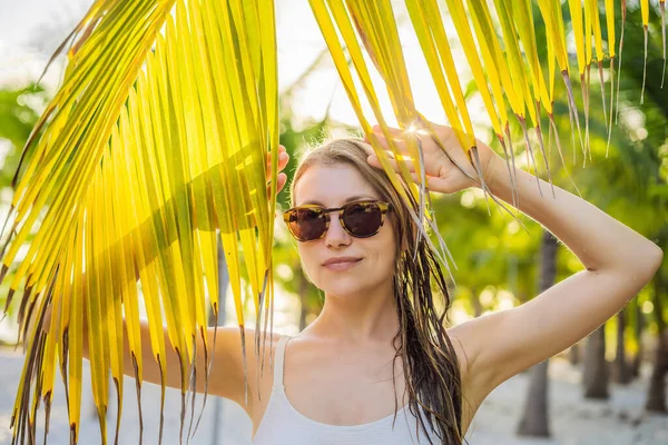 Joven hermosa mujer en traje de baño en la playa tropical, vacaciones de verano, hoja de palmera, piel bronceada, arena, sonriente, feliz. Mujer viajera feliz —  Fotos de Stock