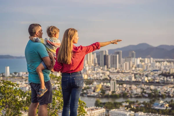 Felices turistas familiares en el fondo de la ciudad de Nha Trang. Viajar a Vietnam con niños Concepto —  Fotos de Stock