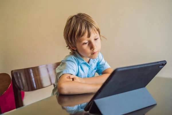 Menino estudando on-line em casa usando tablet. Estudar durante a quarentena. Vírus da pandemia global covid19 — Fotografia de Stock