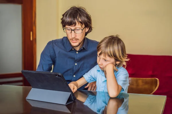 Niño estudiando en línea en casa usando una tableta. Padre le ayuda a aprender. Estudiar durante la cuarentena. Virus covidémico pandémico global19 — Foto de Stock