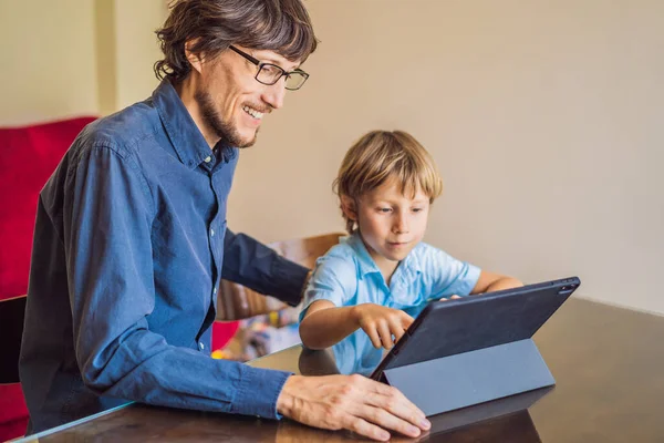 Niño estudiando en línea en casa usando una tableta. Padre le ayuda a aprender. Estudiar durante la cuarentena. Virus covidémico pandémico global19 — Foto de Stock