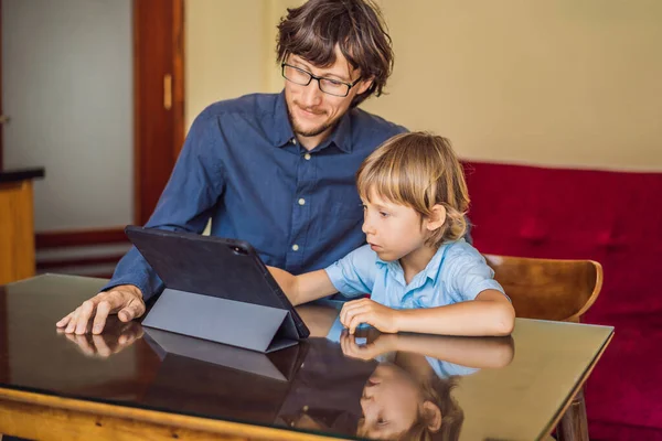 Niño estudiando en línea en casa usando una tableta. Padre le ayuda a aprender. Estudiar durante la cuarentena. Virus covidémico pandémico global19 — Foto de Stock