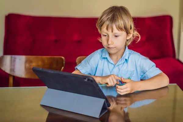 Menino estudando on-line em casa usando tablet. Estudar durante a quarentena. Vírus da pandemia global covid19 — Fotografia de Stock