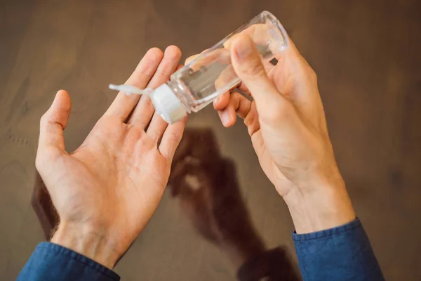Руки с помощью геля для мытья рук. Прозрачный антисептик в бутылке насоса, для убийства микробов, бактерий и вирусов — стоковое фото