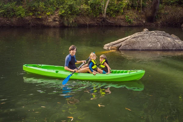 Ein Mann und zwei Jungen in einem Kajak auf dem Fluss. Glückliche Kindheit — Stockfoto