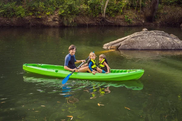 Een man en twee jongens in een kajak op de rivier. Gelukkige jeugd — Stockfoto