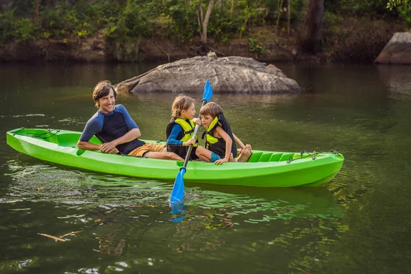 A man and two boys in a kayak on the river. Happy childhood — Stock Photo, Image