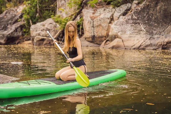 SUP Stand up paddle board femme paddle board sur le lac debout heureux sur paddleboard sur l'eau bleue. Action coup de jeune femme sur planche à pagaie — Photo