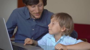 Genç bir adam ve küçük oğlu karantina sırasında bir evde oturup internet okulunda tablet kullanarak okuyorlar. Corona virüsü konsepti