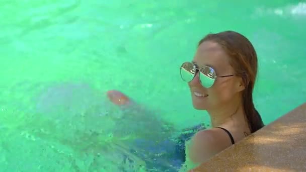 Una giovane donna in un resort tropicale con sorgenti termali, cascate e piscine con acqua minerale calda — Video Stock