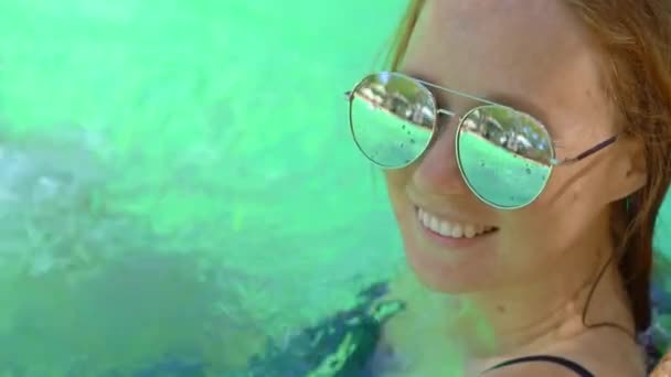 Een jonge vrouw in een tropisch resort met warmwaterbronnen, watervallen en zwembaden met warm mineraalwater — Stockvideo