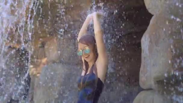 Una joven en un resort tropical con aguas termales, cascadas y piscinas con agua mineral caliente — Vídeo de stock