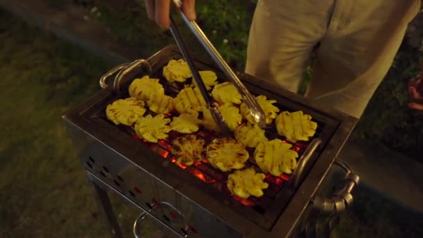 Una barbacoa por la noche. El hombre cocina verduras en una parrilla — Vídeos de Stock