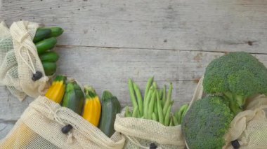 Ahşap arka planda tekrar kullanılabilir poşetlerde renkli sebzeler. Sıfır kayıp. Plastik atık kavramını küçült