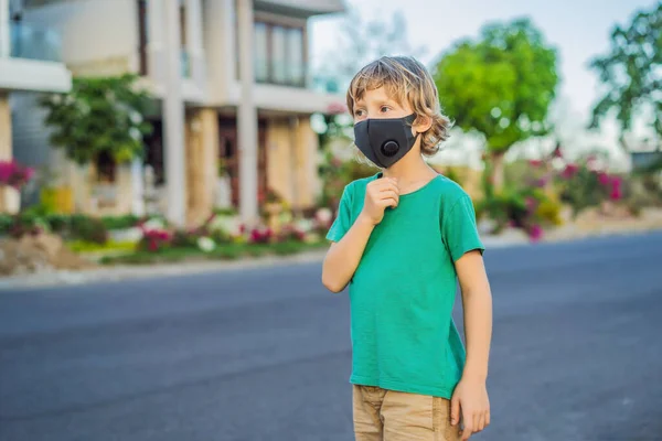 Maschera medica nera alla moda con filtro nella città. Concetto di epidemia di Coronavirus 2019-ncov. Un ragazzo con una maschera medica nera. Ritratto di un uomo con occhi espressivi durante un'epidemia di virus o malattia — Foto Stock