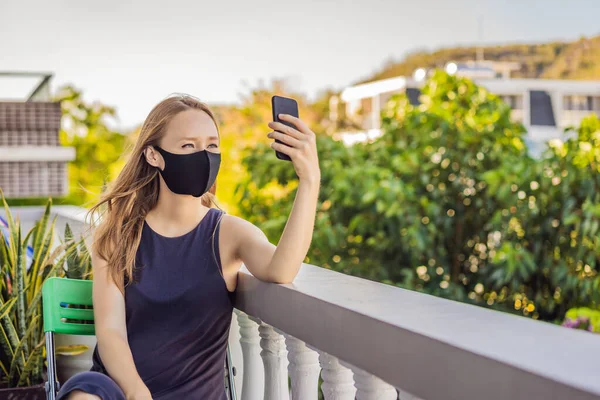 Coronavirus. Woman in quarantine for coronavirus wearing protective mask. Shes working from home and using video call. Video conference — Stock Photo, Image