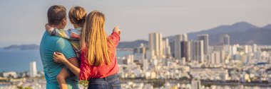 Nha Trang şehrinin arka planında mutlu aile turistleri. Çocuklarla Vietnam 'a seyahat BANNER' I KURUMU, KURUMU