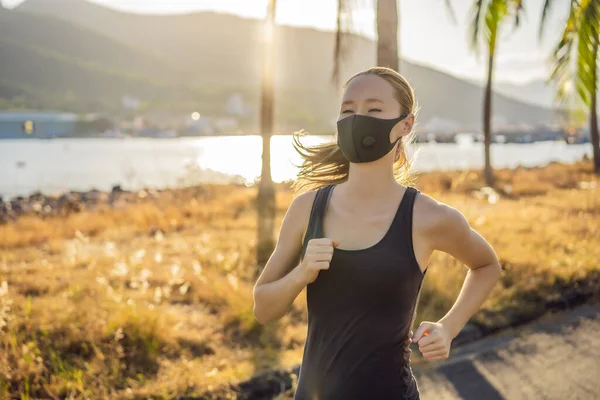 Runner wearing medical mask, Coronavirus pandemic Covid-19. Sport, Active life in quarantine surgical sterilizing face mask protection. Outdoor run on athletics track in Corona Outbreak. Keep your