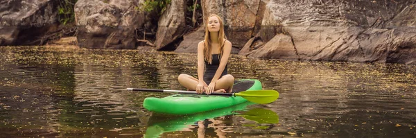SUP Stand up paddle board vrouw paddle boarding op meer staan blij op paddleboard op blauw water. Action Shot of Young Woman on Paddle Board BANNER, LANG FORMAT — Stockfoto
