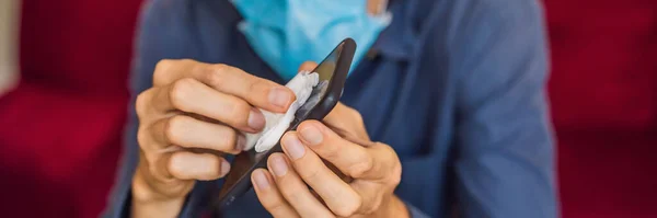 Homme nettoyage écran de smartphone avec de l'alcool ou un désinfectant. Concept de nettoyage téléphone écran sale pour la prévention des maladies contre les bactéries. coronavirus covid 19 BANNER, FORMAT LONG — Photo