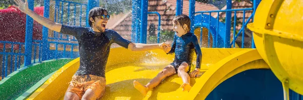 Père et fils sur un toboggan dans le parc aquatique BANNER, LONG FORMAT — Photo