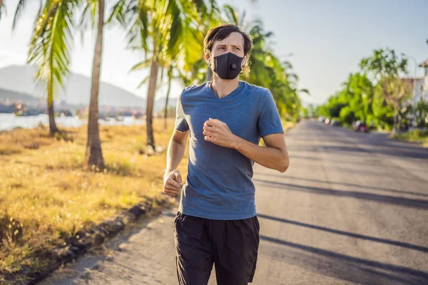 Läufer mit medizinischer Maske, Coronavirus-Pandemie Covid-19. Sport, Aktives Leben in der chirurgischen Quarantäne, sterilisierender Mundschutz. Outdoor-Lauf auf der Leichtathletikbahn in Corona Outbreak. Behalten Sie Ihre — Stockfoto