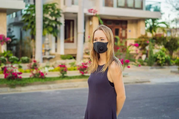 Fashionable black medical mask with filter in the city. Coronavirus 2019-ncov epidemic concept. Woman in a black medical mask. Portrait of a woman with expressive eyes during a virus or disease