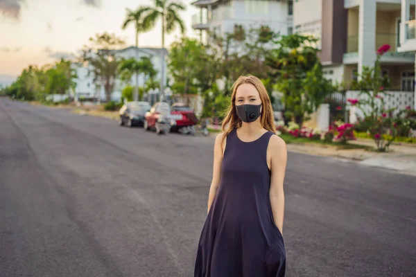 Modna czarna maska medyczna z filtrem w mieście. Koncepcja epidemii koronawirusa 2019-ncov. Kobieta w czarnej masce medycznej. Portret kobiety z wyrazistymi oczami w czasie trwania wirusa lub choroby — Zdjęcie stockowe