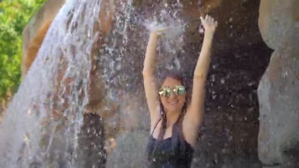 一个年轻女子在热带度假胜地，有温泉，瀑布和游泳池与热水矿物水。慢动作射击 — 图库视频影像
