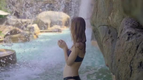 Молодая женщина в тропическом курорте с горячими источниками, водопадами и бассейнами с горячей минеральной водой. Слоумоушн — стоковое видео