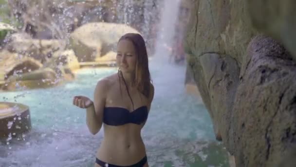 Eine junge Frau in einem tropischen Resort mit heißen Quellen, Wasserfällen und Schwimmbädern mit heißem Mineralwasser. Zeitlupenschuss — Stockvideo