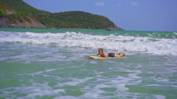 La toma en cámara lenta de una joven está surfeando en un hermoso mar — Vídeo de stock