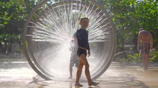 Kleine jongens komen door een ronde massagedouche in aquapark — Stockvideo